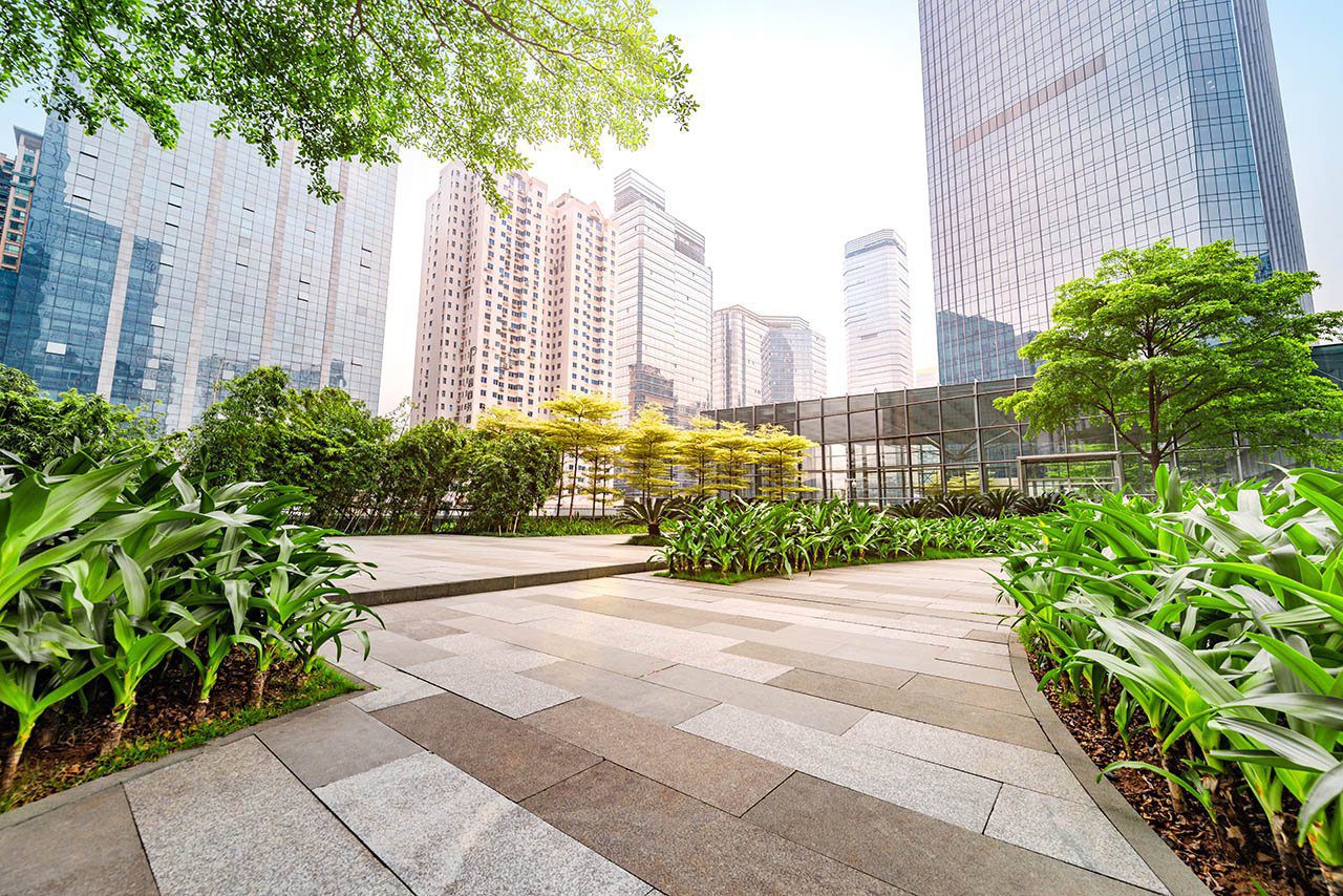 Green landscape walkway Landscaped urban walking path with trees, plants, and greenery, providing a peaceful outdoor space in the city.