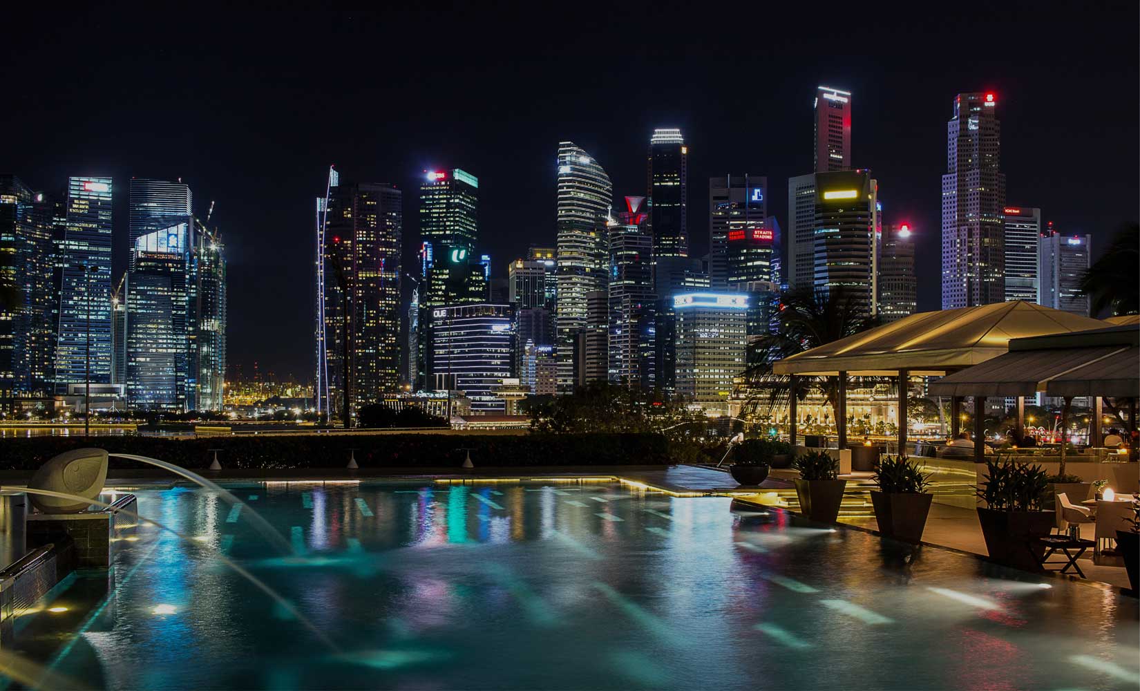 Dubai skyline with illuminated commercial high-rise buildings and pool, showcasing professional leak detection services.