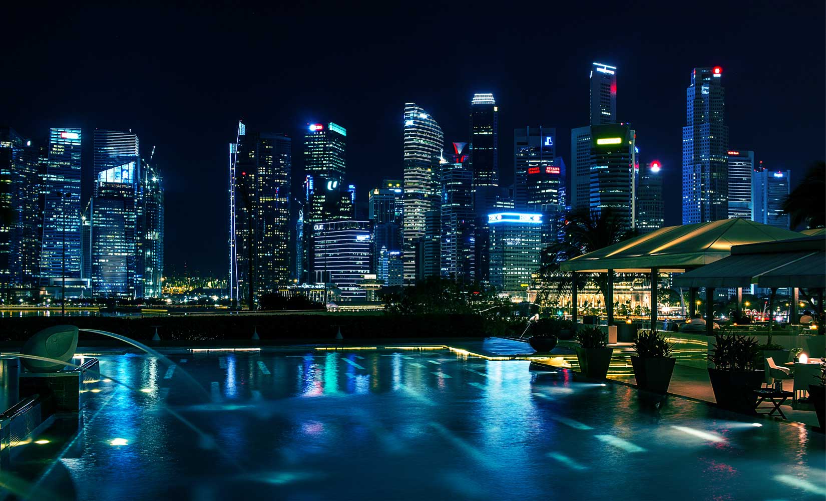 Dubai skyline with illuminated commercial high-rise buildings and pool, showcasing professional leak detection services.
