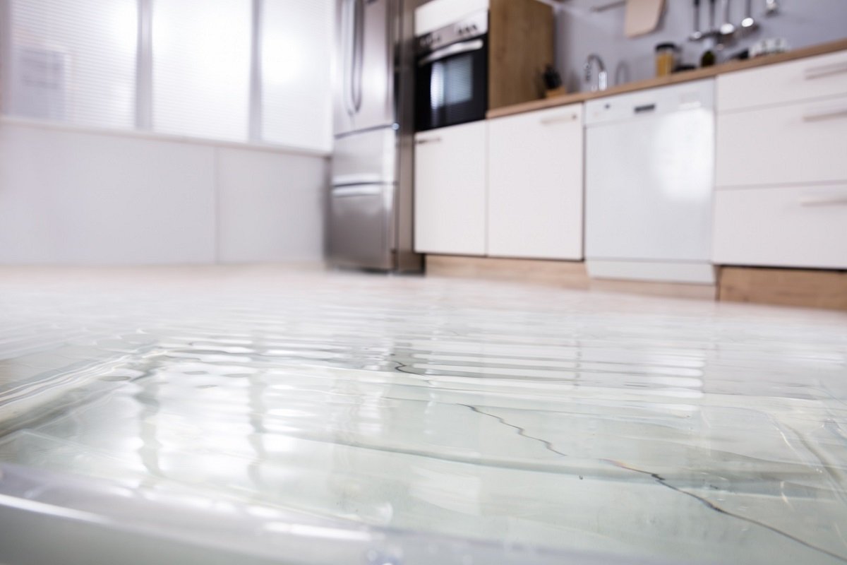 Close-up of flooded kitchen floor caused by a hidden plumbing or appliance leak
