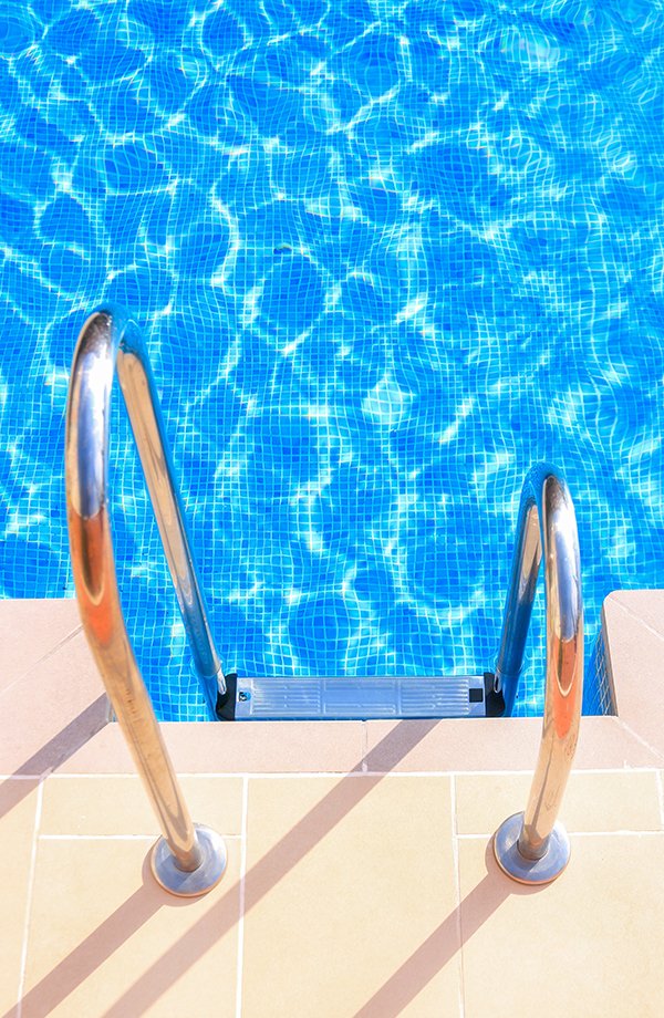 Blue swimming pool with metal ladder