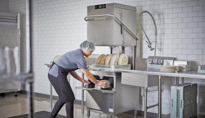 Worker washing dishes in drain line