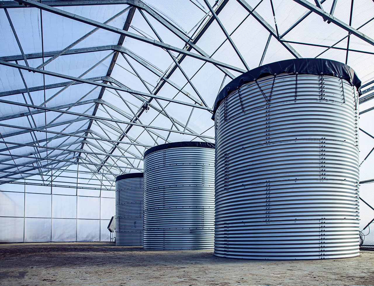 Industrial metal water storage tanks inside a facility.