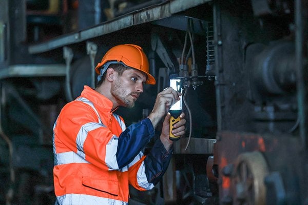 Engineer inspecting plumbing lines with a flashlight
