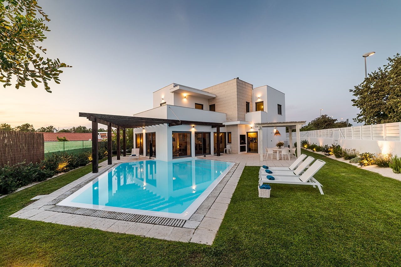 Modern residential villa with a swimming pool surrounded by landscaped outdoor areas.