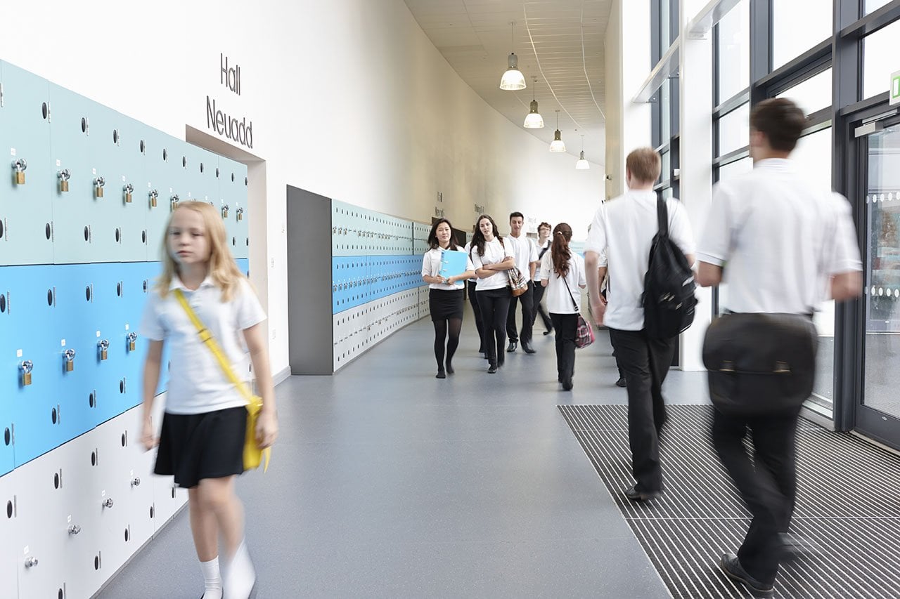 Children walking in a school corridor, emphasizing safe and well-maintained school facilities.