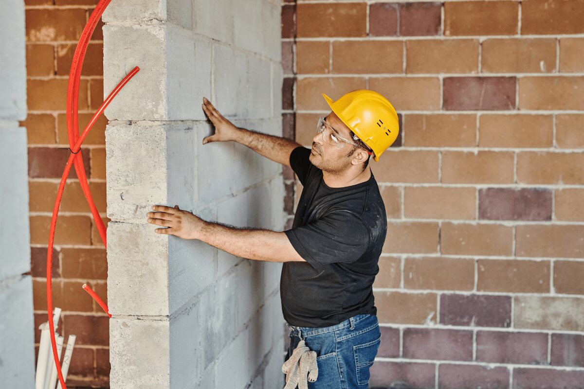 Man inspecting a concrete wall for damage