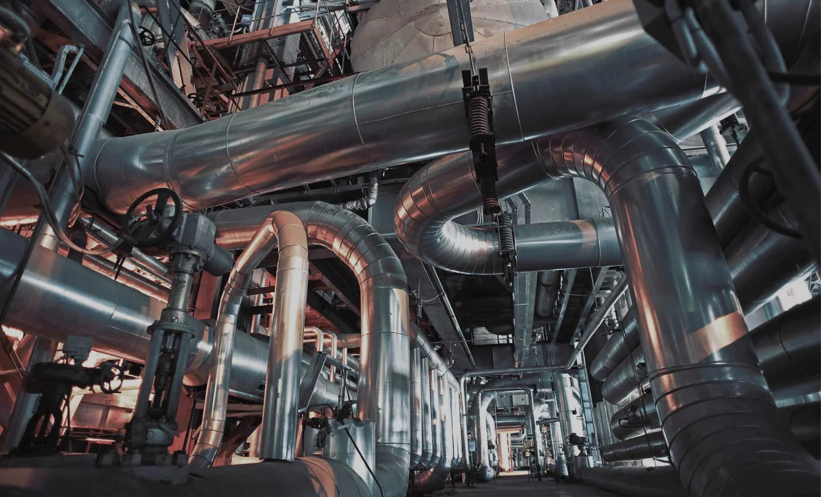 Industrial steel piping system for district cooling inspected for hidden water leaks in a Dubai facility.